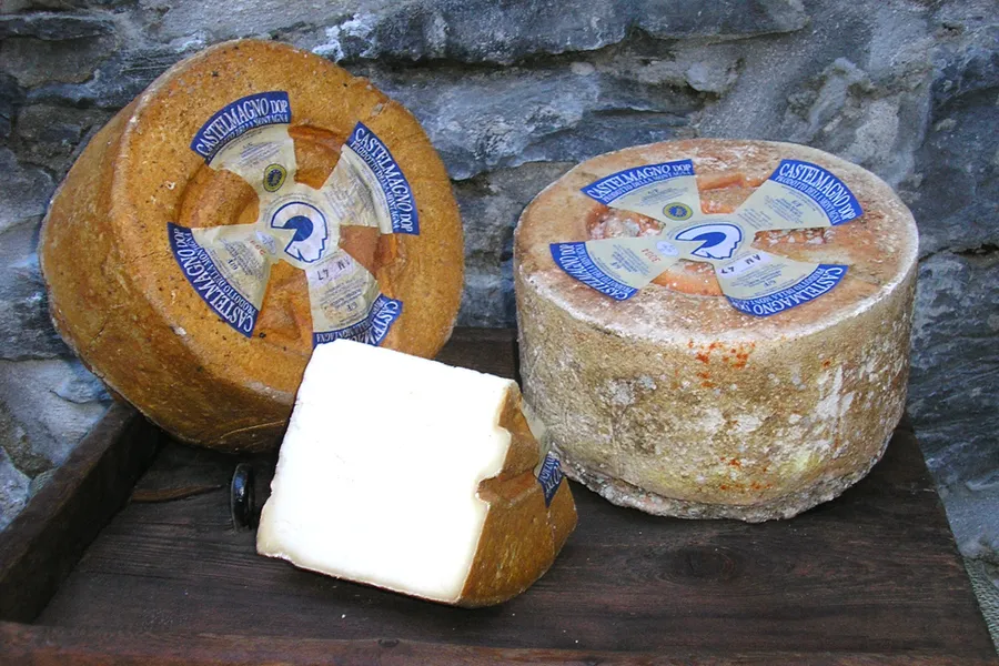 Due forme di Castelmagno e una fetta appena tagliata