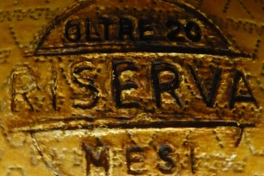 La marchiatura «Riserva oltre 20 mesi» impressa sulla crosta di una forma di Grana Padano