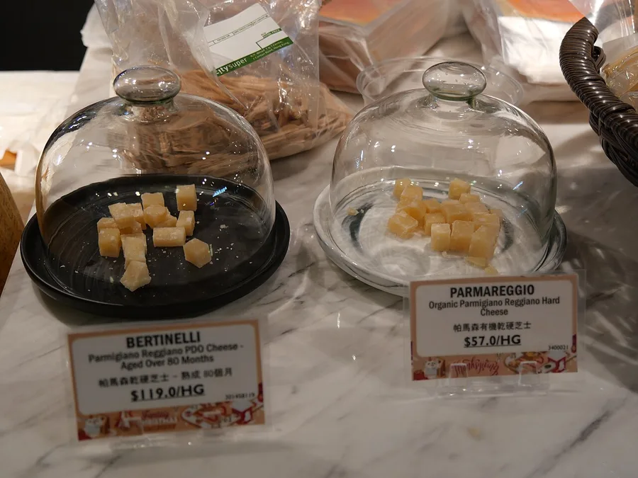 Punte di formaggio sotto campane di vetro con i cartellini del prezzo