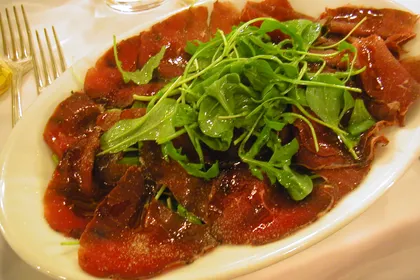 Bresaola affettata con rucola, servita come antipasto