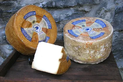Due forme di Castelmagno e una fetta appena tagliata