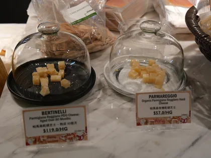 Punte di formaggio sotto campane di vetro con i cartellini del prezzo