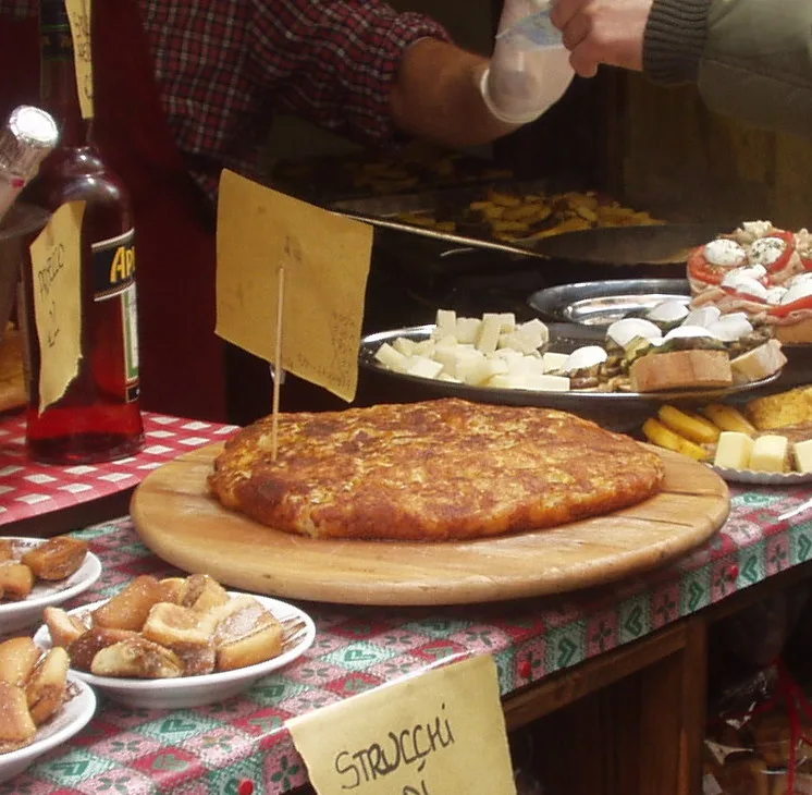 Frico tenero con patate, dorato sui bordi, servito su un tagliere