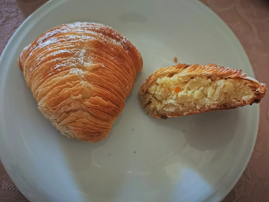 Due sfogliatelle ricce a ventaglio, una tagliata a metà a mostrare gli strati